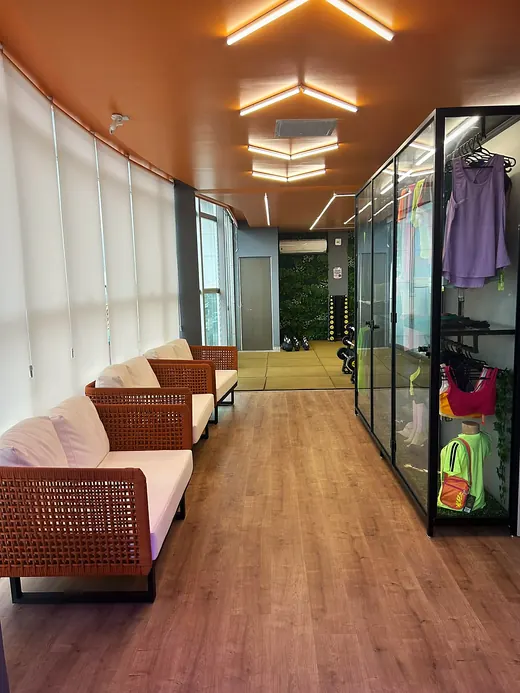 Lounge com sofás e a vitrine da loja ao lado.