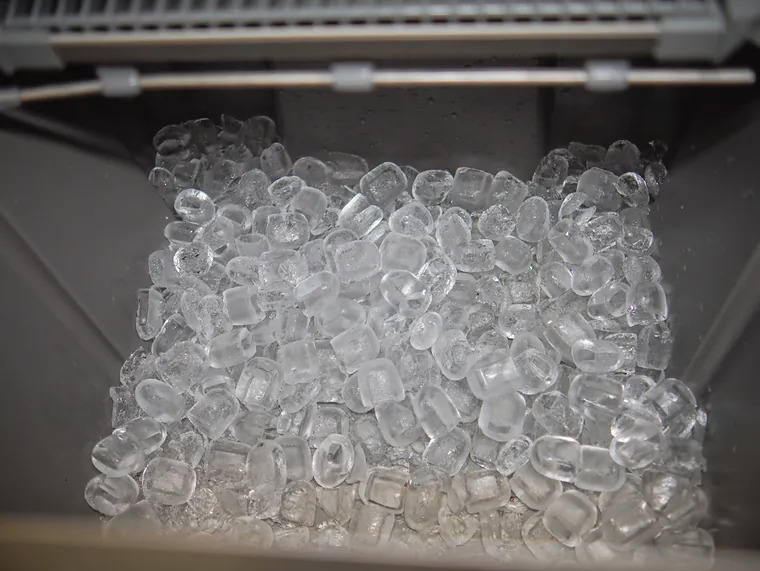 Cubos de gelo transparentes dentro da máquina.